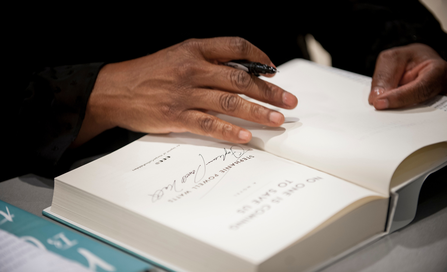 Author signs book.