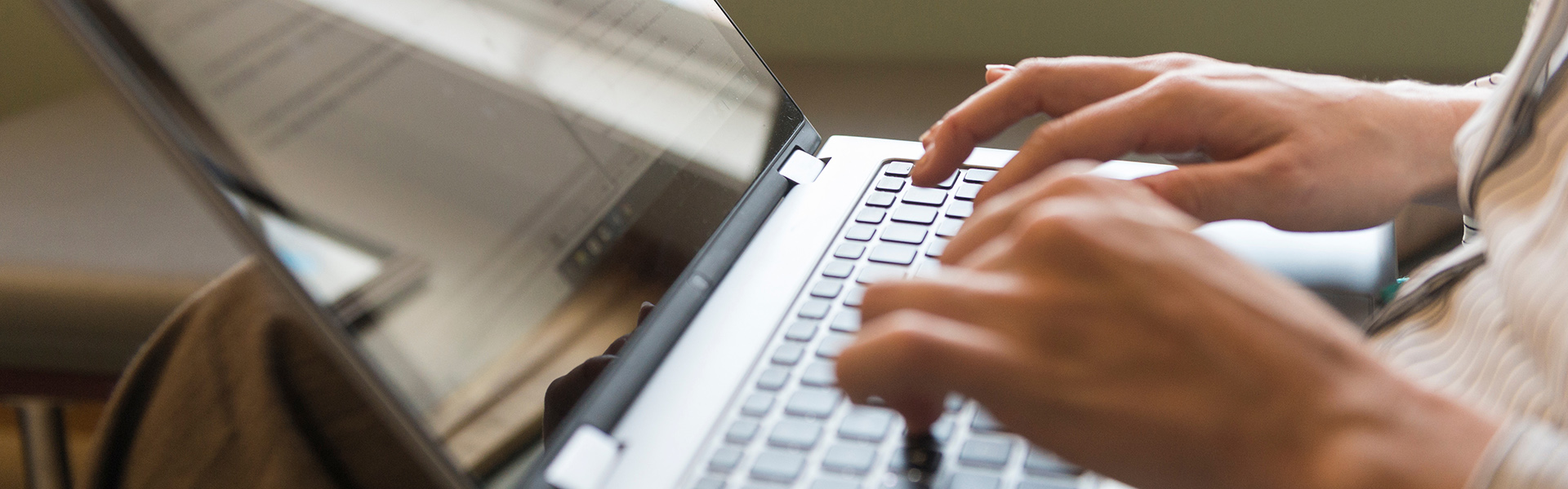 student typing on laptop