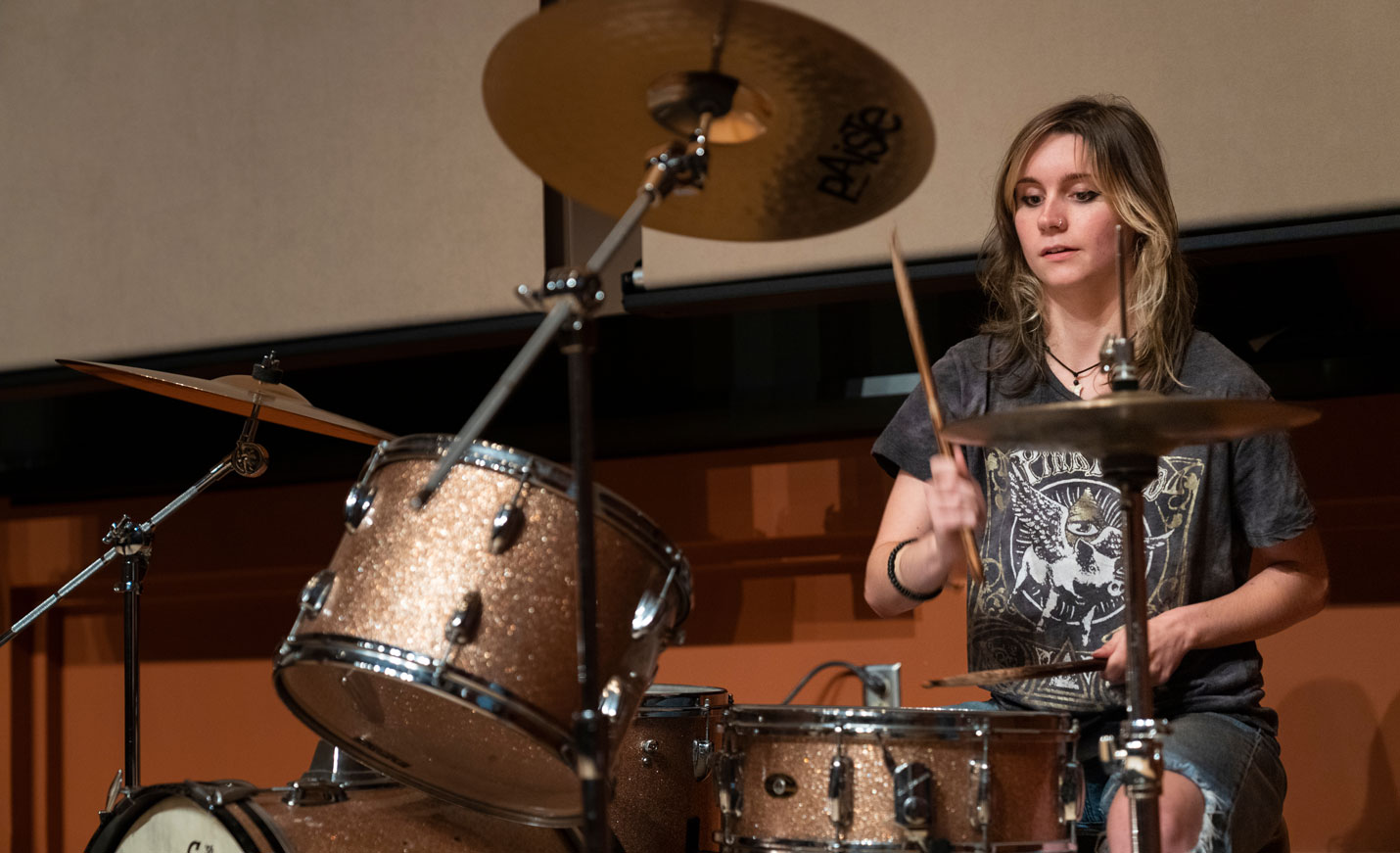 A student playing a drum set
